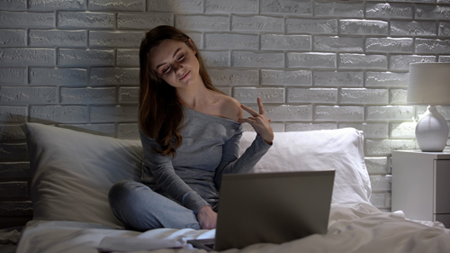 ragazza a letto con computer